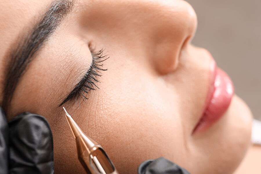 Young woman undergoing procedure of permanent eye makeup in tattoo salon, closeup Imagen de Young woman undergoing procedure of permanent eye makeup in tattoo salon, closeup